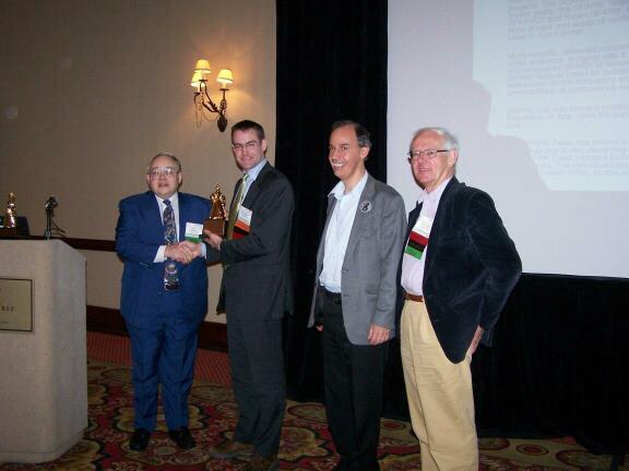 Currie Colket presents the Outstanding Ada Community Contribution Award to SPARK Team members Rod Chapman, Brian Dobbing, and John Barnes