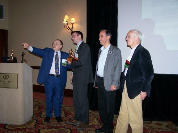 Currie Colket presents the Outstanding Ada Community Contribution Award to SPARK Team members Rod Chapman, Brian Dobbing, and John Barnes