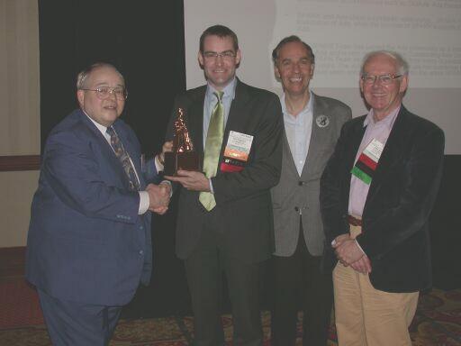 Currie Colket presents the Outstanding Ada Community Contribution Award to SPARK Team members Rod Chapman, Brian Dobbing, and John Barnes